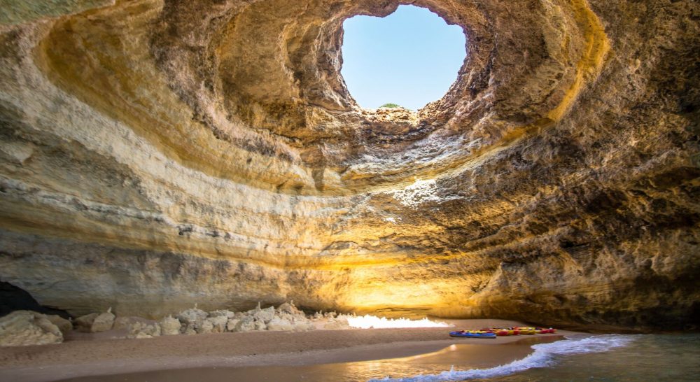 Benagil cave with sunshine coming through the hole in the top of the cave.