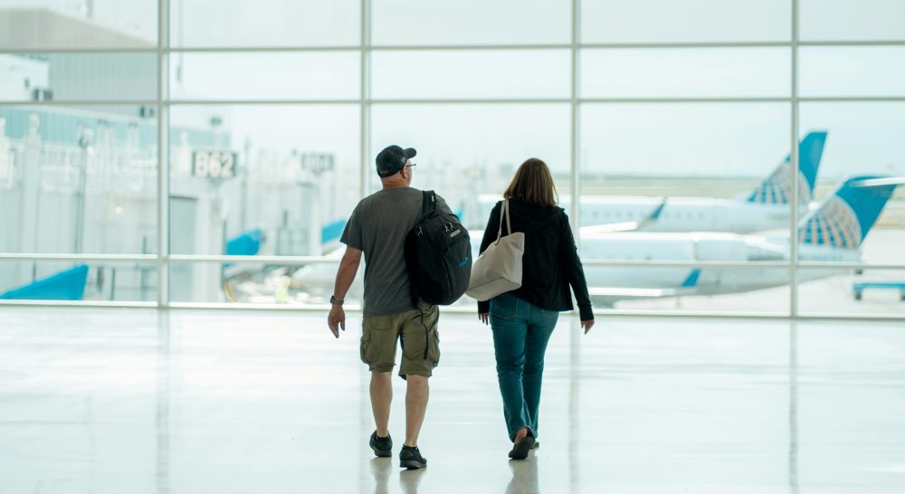Two people walking through an aiport